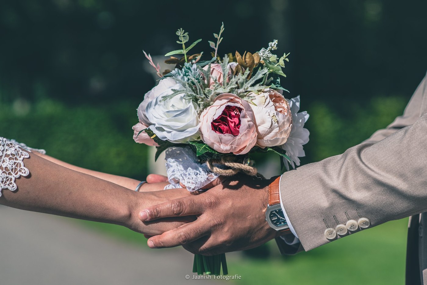 Bruidsboeket en de handen van het bruidspaar